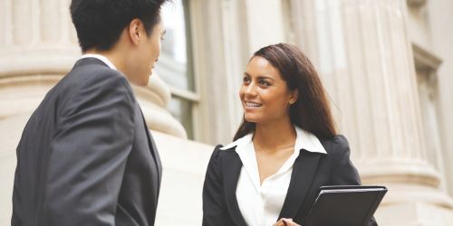 Paralegal and attorney talking outside a courthouse