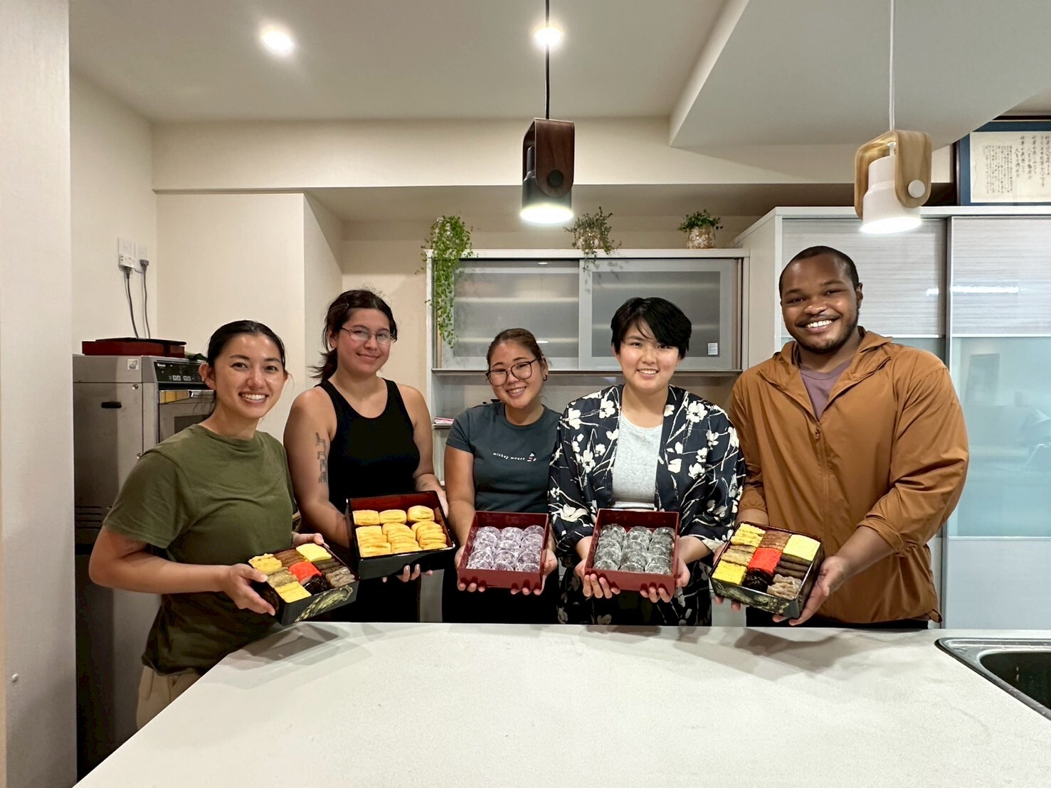 OMI undergraduate team members presenting traditional Ryukyuan (Okinawan) foods they made with KEMPI (Okinawan Emigrants’ Descendant and Asian Scholarship Program) students studying under Masterchef Tsukayama Keiko.