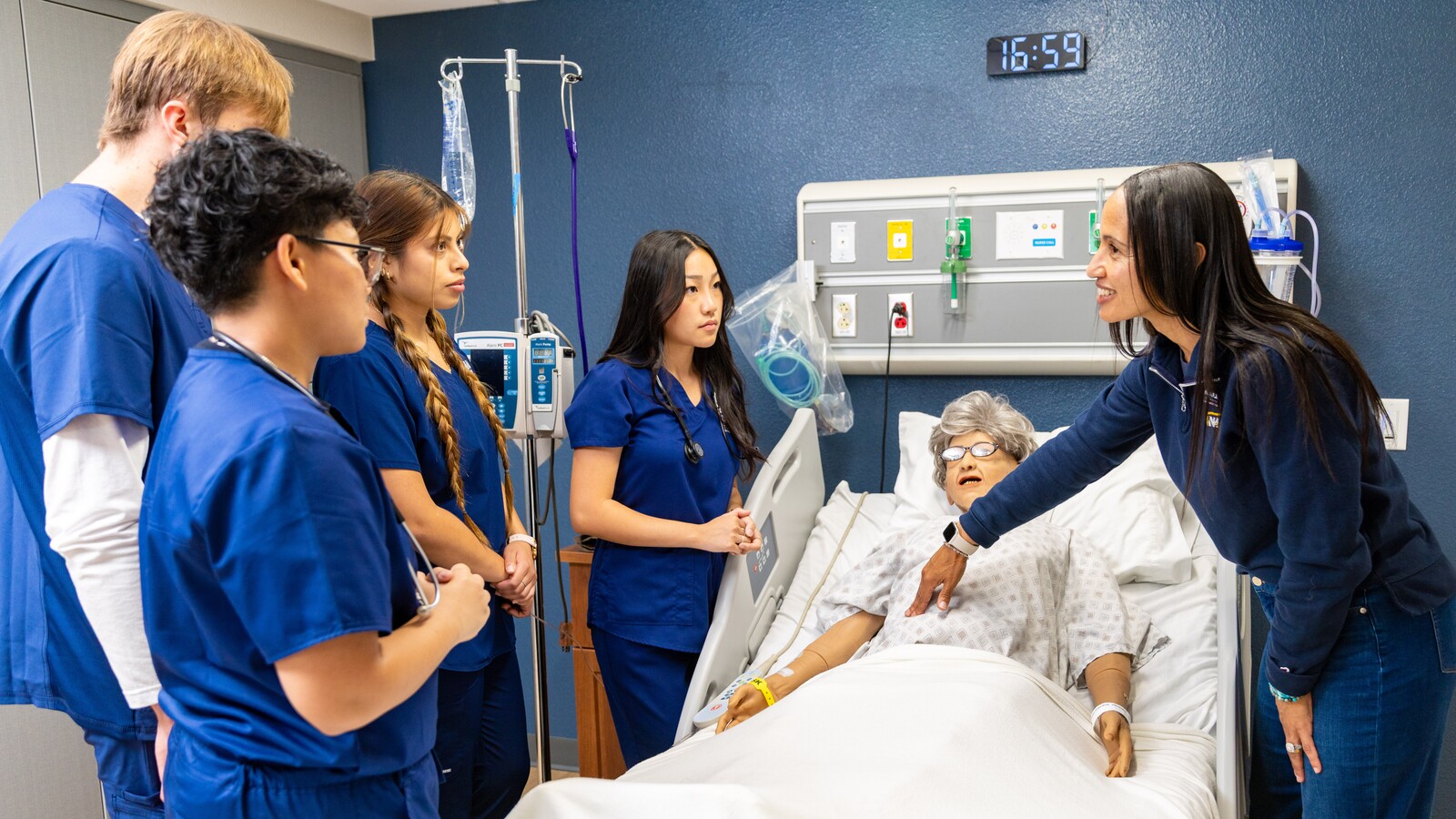 A group of nursing students learn how to examine a medical mannequin. A group of nursing students learn how to examine a medical mannequin.