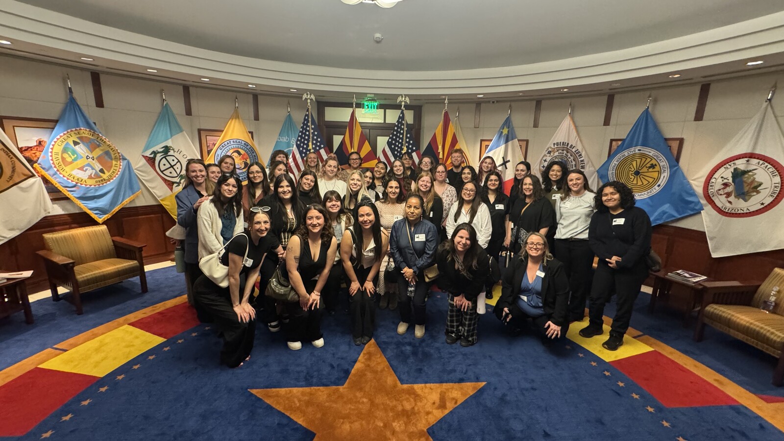 A group of NAU students pose and smile in a government building. A group of NAU students pose and smile in a government building.