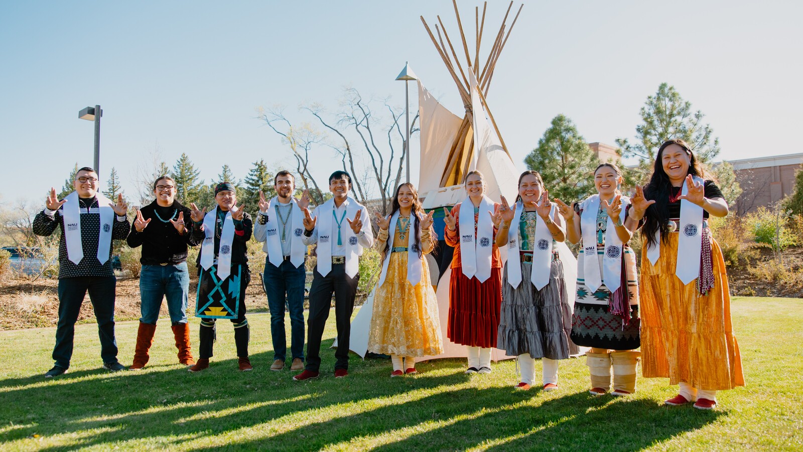 Students with the Center for Native American and Indigenous Futures pose with their graduation stole holding up "LJs."
