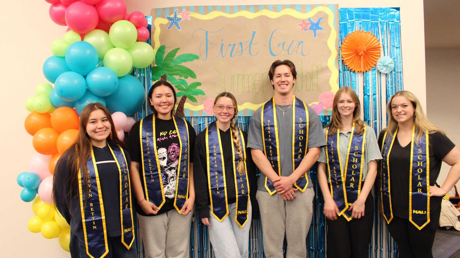 A group of NAU students pose in front of a banner that reads "First-gen Summer Send-off".
