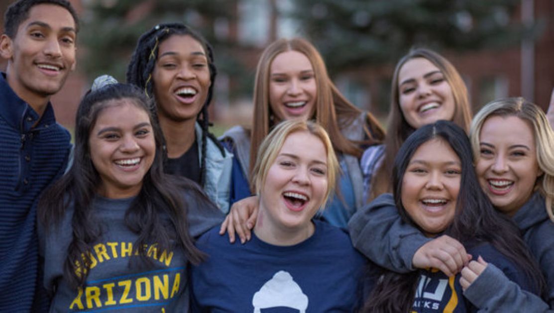 A group of NAU students gather and smile. A group of NAU students gather and smile.