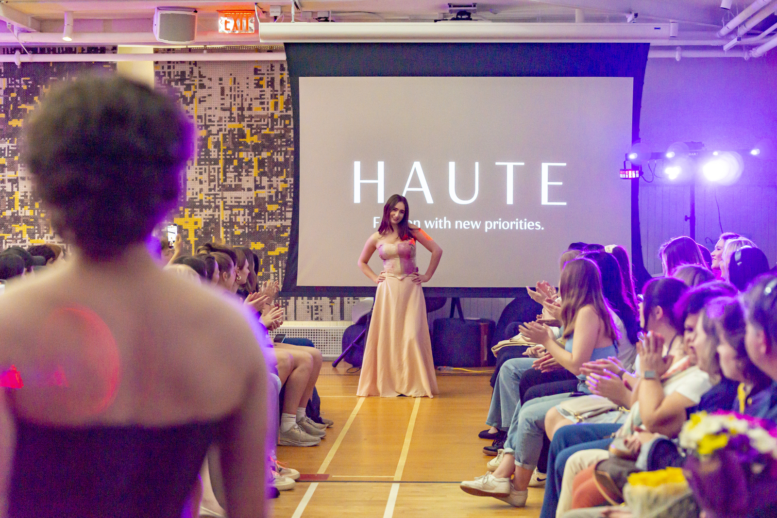 A student walks down the Haute Fashion Show runway in a white dress. A student walks down the Haute Fashion Show runway in a white dress.