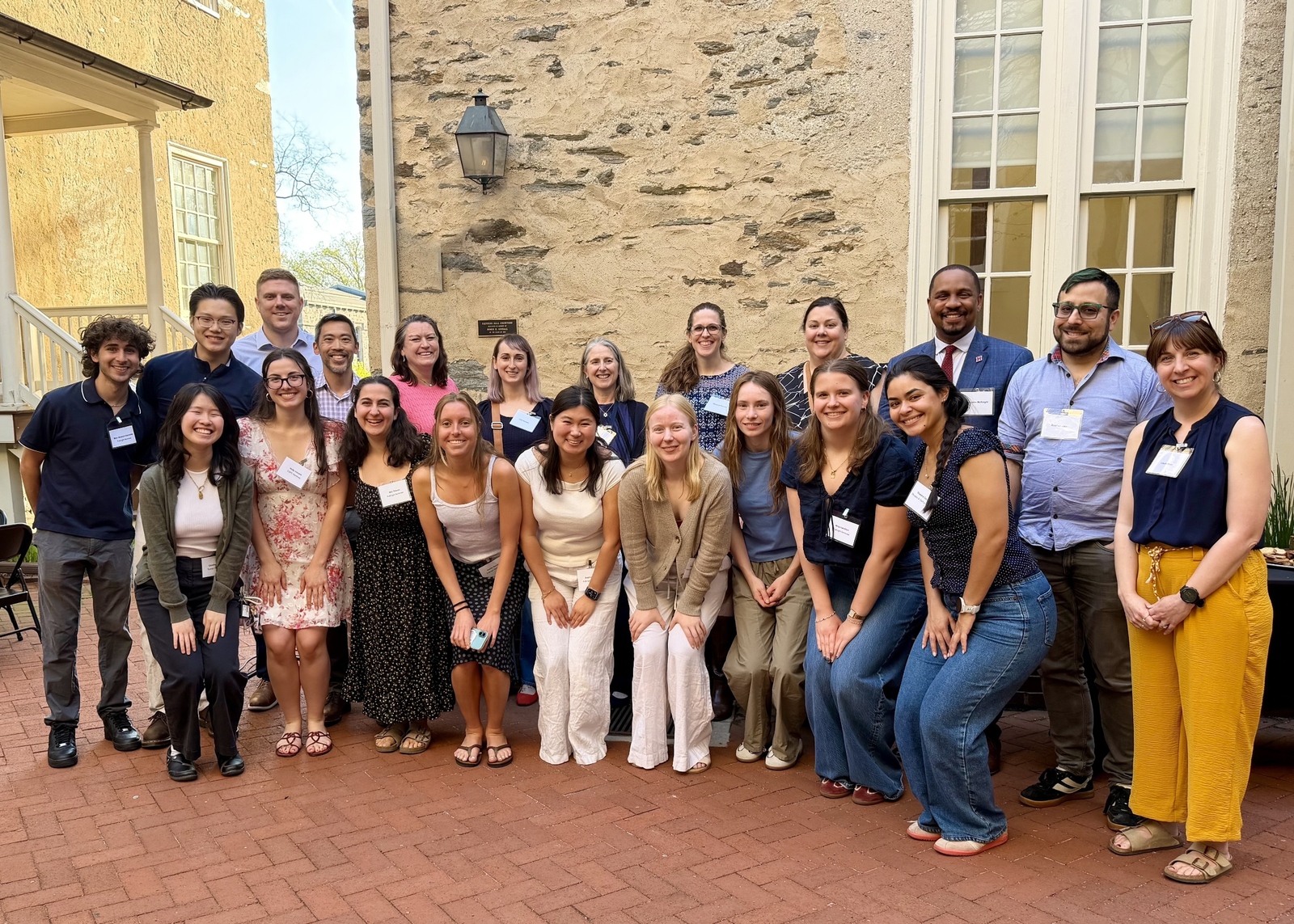 A group of students pose and smile outside Founders Hall following a celebration